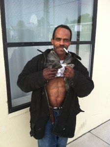  This is the Homey Green Eyes I love this guy Because he is one of the funniest most engaging characters in my neighborhood. We meet one day when he was in the garbage room digging through the recycling and we have been friends ever since. One day I ran into him by the dumpster and I was like, “Where you been?” He was like, “I gots shot. Been in the hospital for ten days. Then they put me in rehab, but I was like fuck that shit. You know you cant hold a player down. You wanna see where they shot me?” I was like, “Yeah, let me see that shit.” Next thing I know he drops his pants right there on the sidewalk with all the ease and comfort that your cell mate would have about taking a shit with you lying on the bottom bunk next to him in a 4 by 10 cell. Now here I am standing on the side walk being flashed Dirty Bum Balls. He pulls his dick and balls to the side to display where the bullet went in. Then he says, “You want to see where it came out?”, and I was like, “Hell no! I seen enough blood. ”